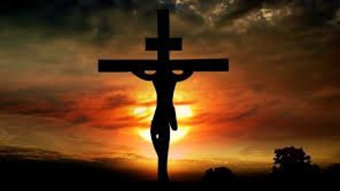 En skygge af Jesus på korset foran en solopgang