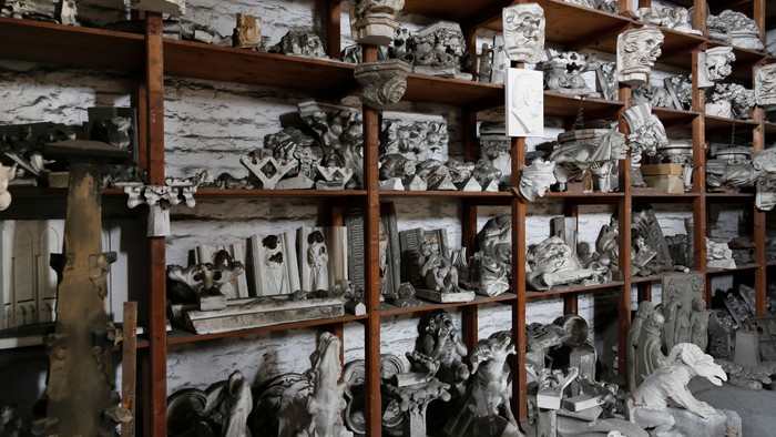 Viele Statuen und Skulpturen auf Regalen in einem Raum