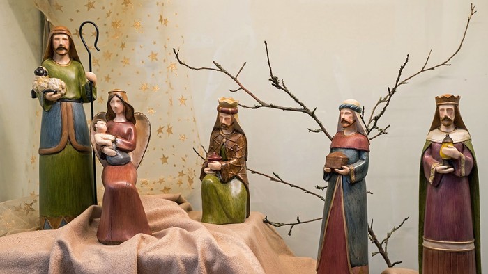 Fünf Figurinen, die eine religiöse Szene darstellen, wahrscheinlich die Weihnachtskrippe, wobei eine ein Baby hält.