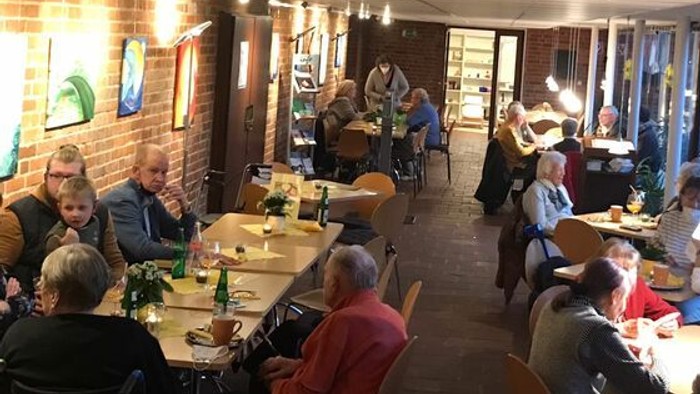 Ein gemütliches Restaurant mit mehreren Gästen, die an Tischen sitzen und essen.