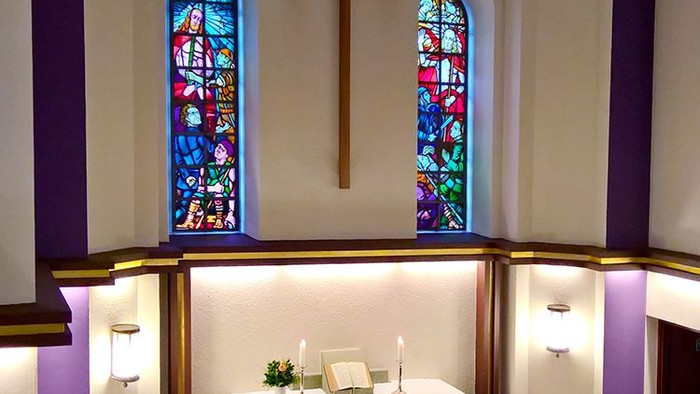 Die Kirche mit einem Altar und zwei buntem Fenstern