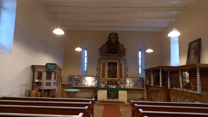 Kirchlicher Innenraum mit Altar und Holzbänken