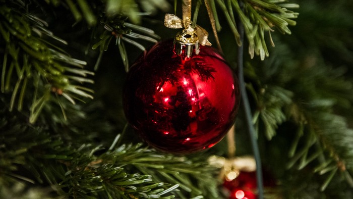 Et rødt pynt hænger på et juletræ.