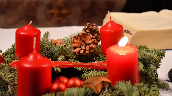 Drei rote Kerzen und Tannenzweige auf Tischdekoration