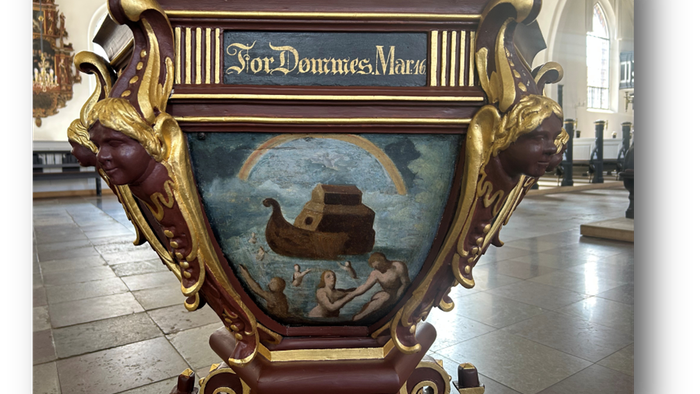 Kirkealter med et maleri af en båd og mennesker, kronet med forgyldte og røde, prægtige udsmykninger.