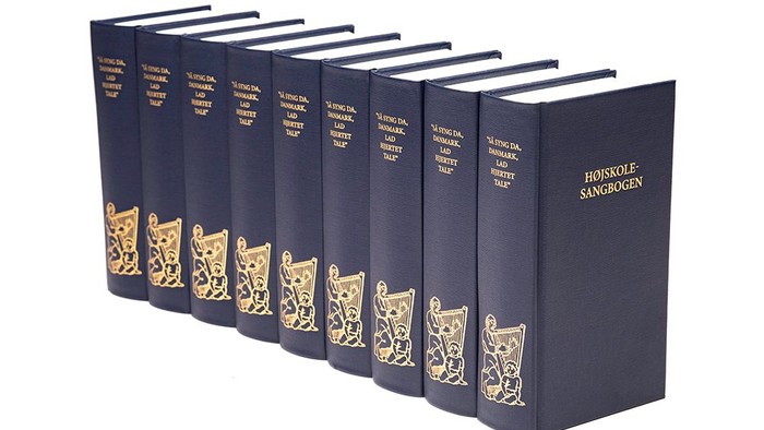 En række blå bogudgaver med guldindtryk og katteillustrationer.