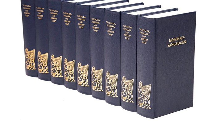 Syv blå bogudgaver med guldpræg og katteillustrationer