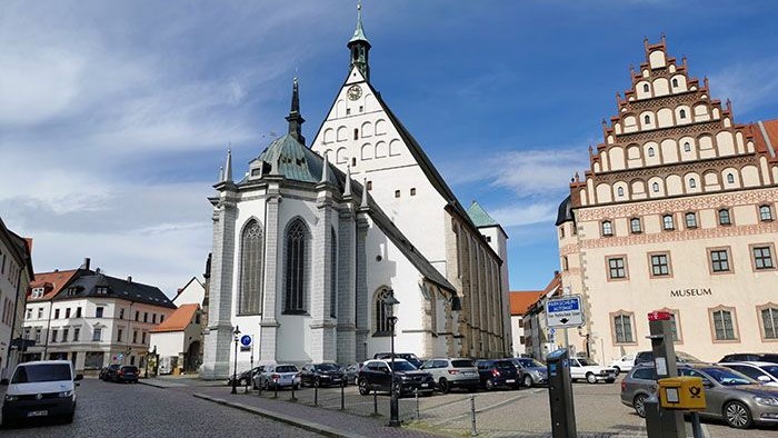 Historische Kirche und Gebäude in Stadtmitte, Autos auf Kopfsteinpflasterstraße