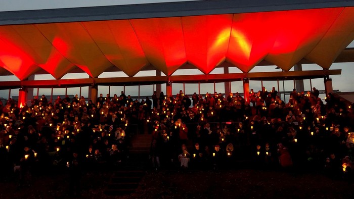 Große Menschenmenge bei Nachtveranstaltung unter rot beleuchtetem Zelt
