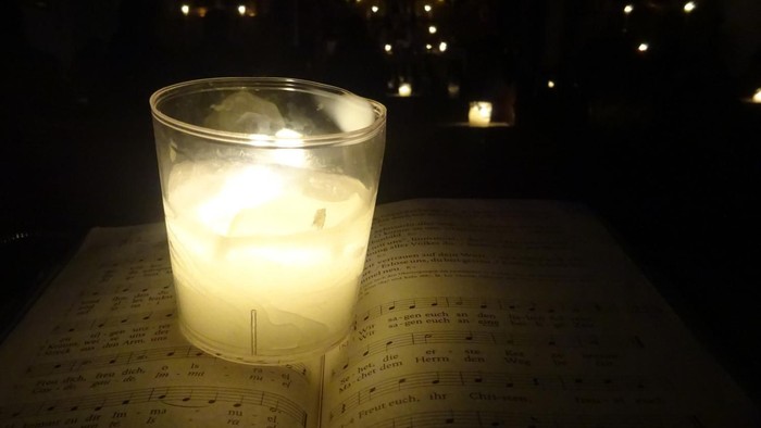 Ein brennendes Teelicht im Glas in der Dunkelheit