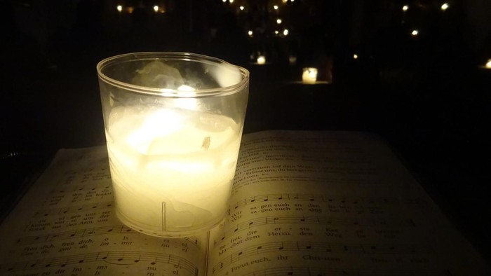 Ein brennendes Teelicht im Glas in der Dunkelheit