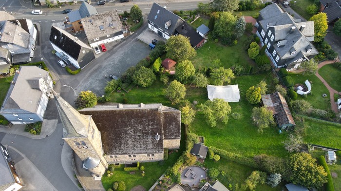 Luftaufnahme eines Dorfes mit Kirche und Häusern