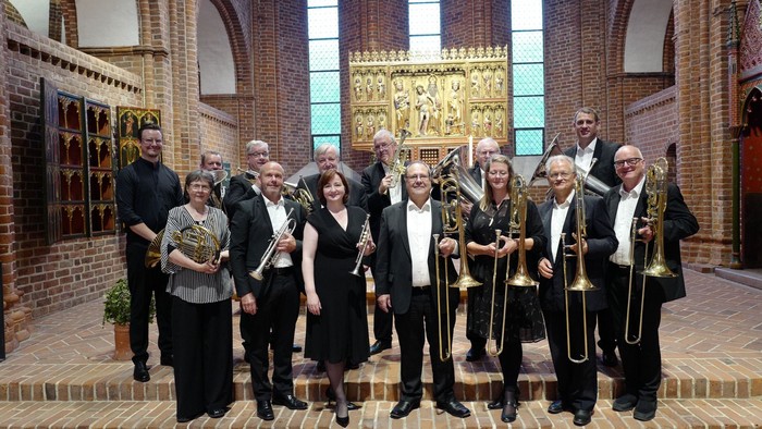 Gruppe af musikere, der poserer med instrumenter i en kirke