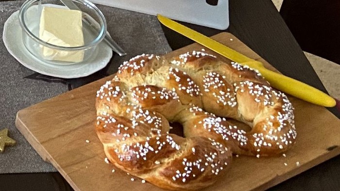 Zwei frisch gebackene Brote mit Butter und Messer auf Schneidebrettern