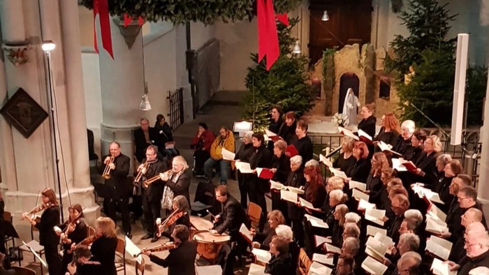 Kirchenchor führt Weihnachtskonzert mit Orchester und Publikum auf.