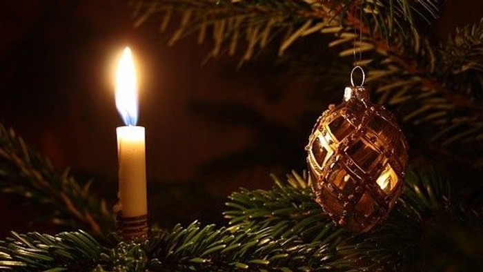 Weihnachtsdekoration mit brennender Kerze und Christbaumkugel
