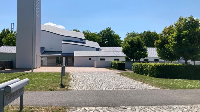 En moderne bygning med fladt tag og stenvej til indfald.