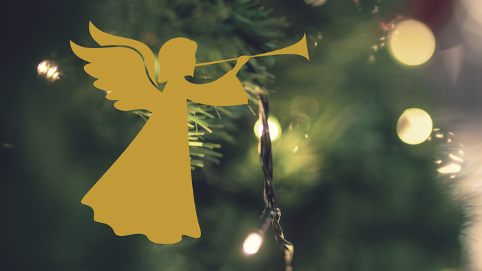 Ein goldener Engel schmückt einen Weihnachtsbaum mit Lichtern