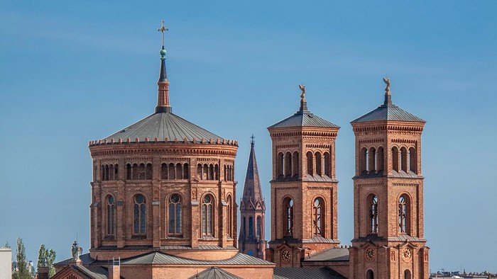 Große Kirche mit zwei Türmen und einer Kuppel, umgeben von kleineren Gebäuden.