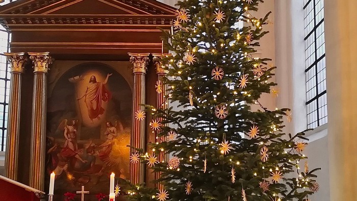 Kircheninneres mit Weihnachtsbaum und Altar.