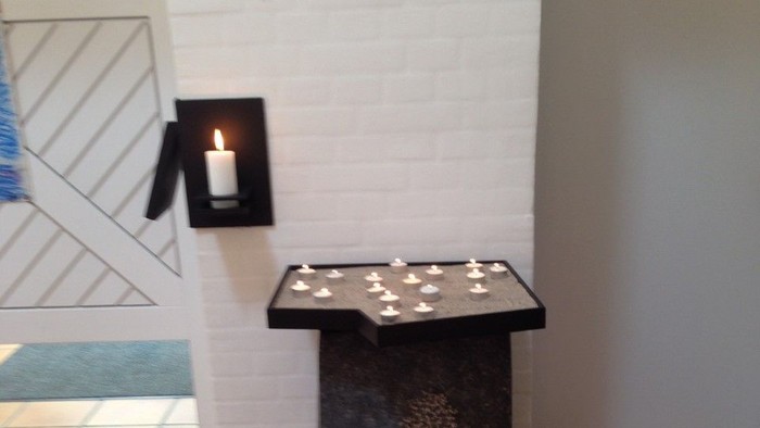 En sort bord med lys på et hvide væg