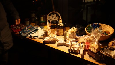 Ein Tisch mit verschiedenen Gegenständen, darunter Kerzen, Vasen und Schalen, im dunklen Raum beleuchtet