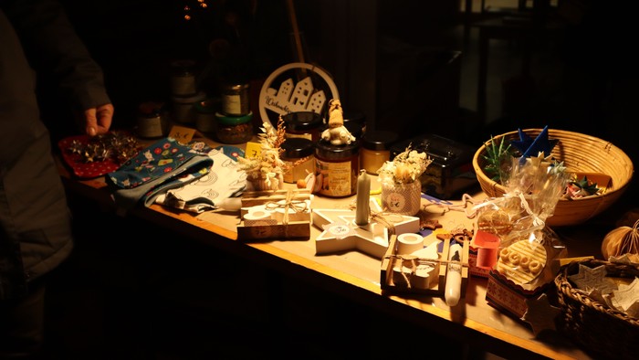 Ein Tisch mit verschiedenen Gegenständen, darunter Kerzen, Vasen und Schalen, im dunklen Raum beleuchtet