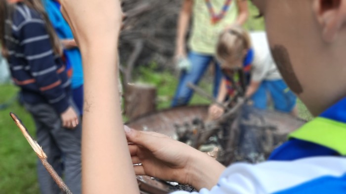 Ein Junge hält einen Stock und zeigt nach oben.