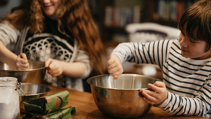 Ein Kind und eine Frau bereiten Essen in der Küche zu.