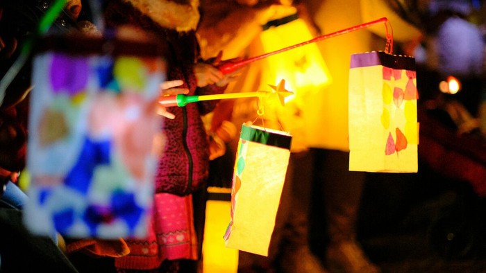 Kinder halten nachts bunte Laternen.