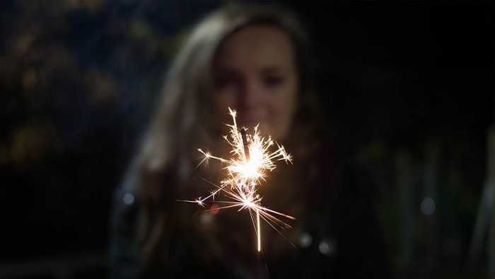Frau hält Wunderkerze vor sich