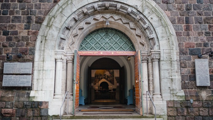 Ein alter Steinbogen mit farbigem Glasfenster an einem Gebäude