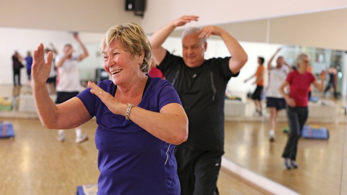 Eine Gruppe älterer Menschen übt Tanzen in einem Studio