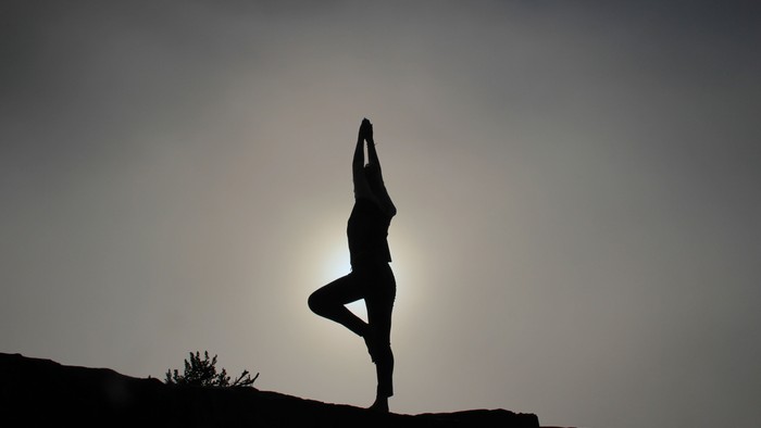 Silhouette einer Person in Yoga-Pose bei Sonnenuntergang