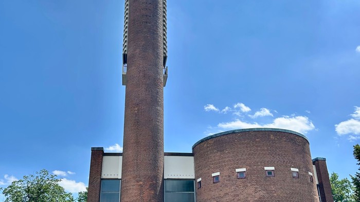 Gebäude mit hohem Schornstein und modernen Fenstern