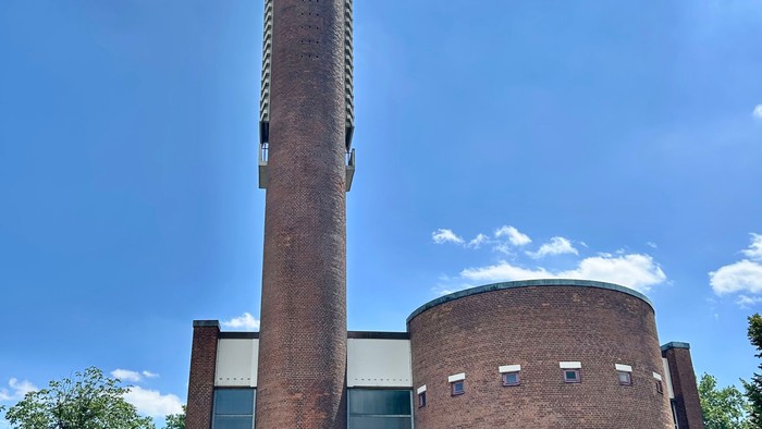 Gebäude mit hohem Schornstein und modernen Fenstern