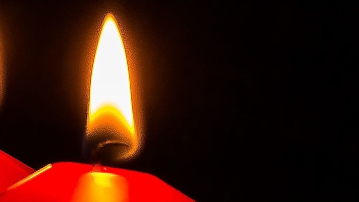 Vier rote Kerzen, drei unangezündet, eine angezündet