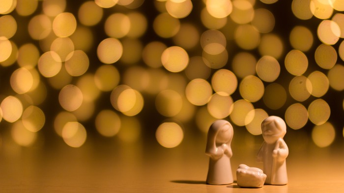 Zwei kleine Holzfiguren vor goldenem Bokeh-Hintergrund