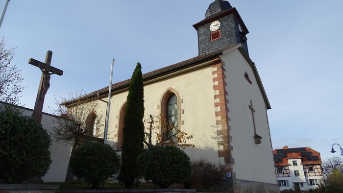Kirchengelände mit Kreuz, Uhrturm und Statue