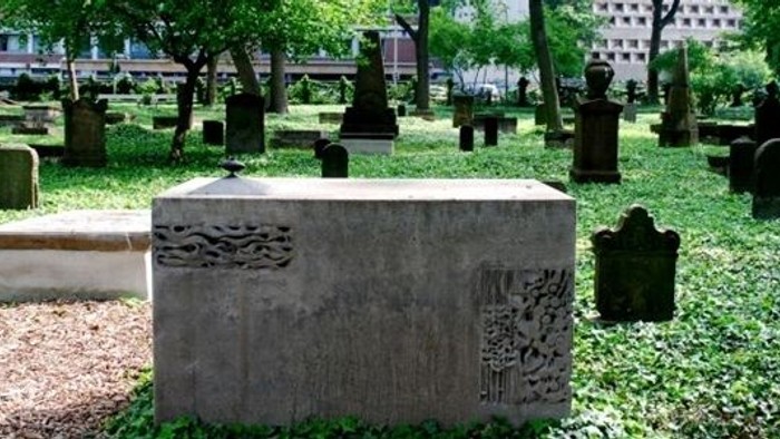 Alter Friedhof mit vielen Grabsteinen und Bäumen