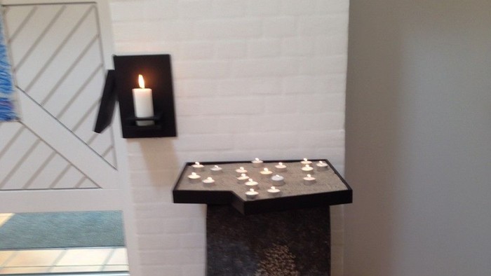 En sort bord med lys på et hvide væg