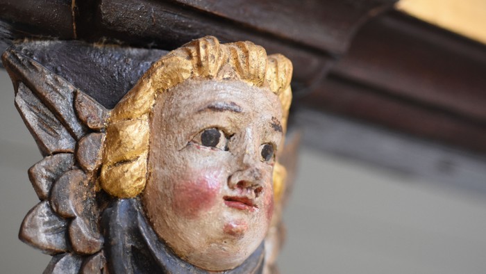 En smuk udskåret figur af en kvinde med gyldne hår og blå øjne.