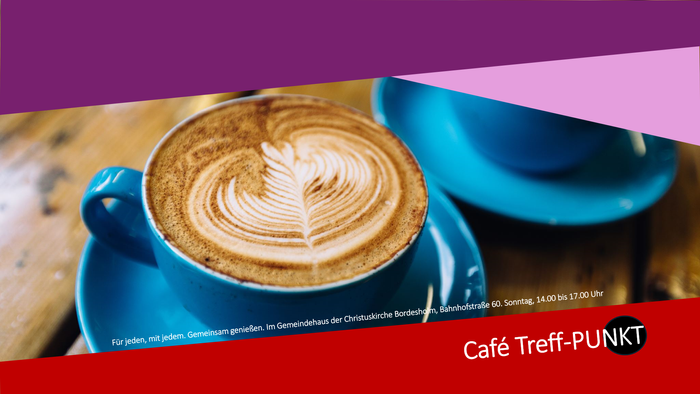 Zwei blaue Kaffeetassen mit Milchschaum auf einem Holztisch