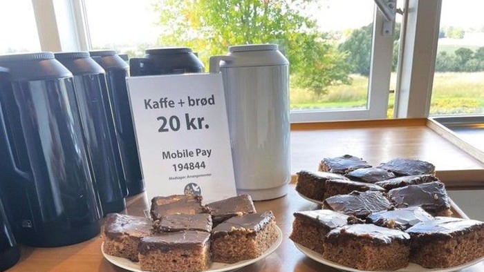 Kaffe og kage udstillet med pris og betalingsinformation