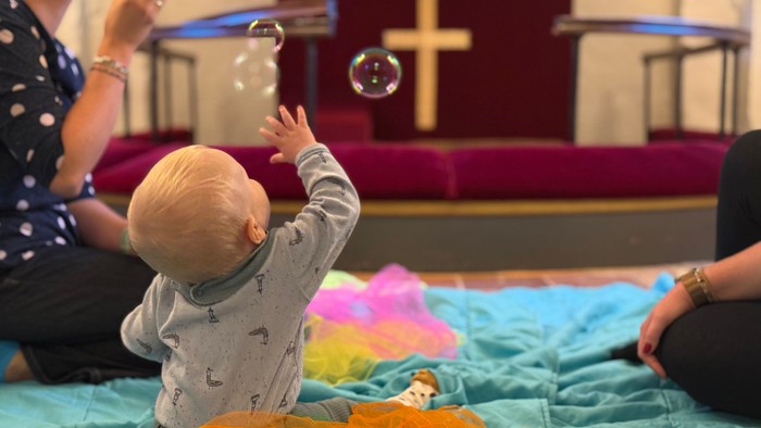 Børn spiller med boblepistolen i kirke.