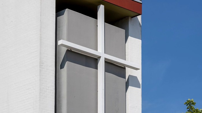 Hvide kors på hvide væg med træ i baggrunden