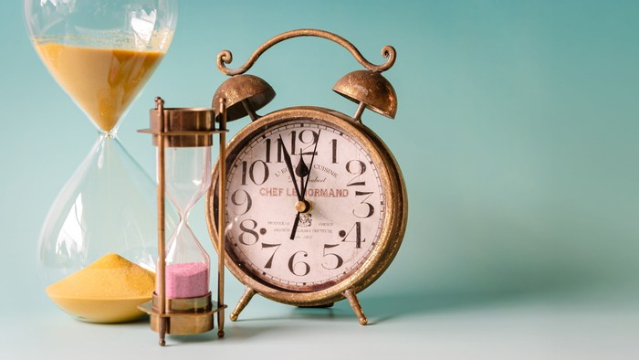 Bild mit einem Wecker und zwei Sanduhren