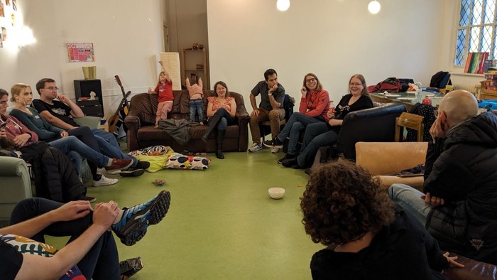 Eine Gruppe von Menschen sitzt in einem Raum und unterhält sich.