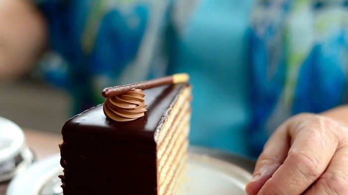 Eine Person hält ein Buch und trinkt Kaffee.