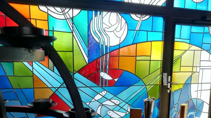 Bunte Kirchenfenster mit Kerzen und Tisch